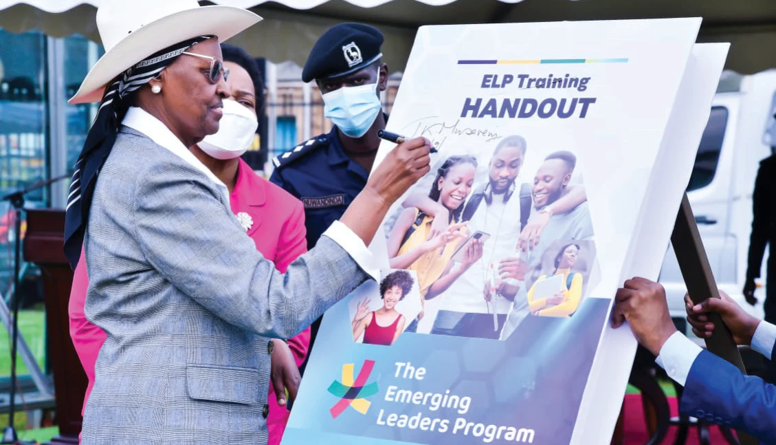 Hon. Janet Kataaha Museveni signs an ELP training handout at a programme event.